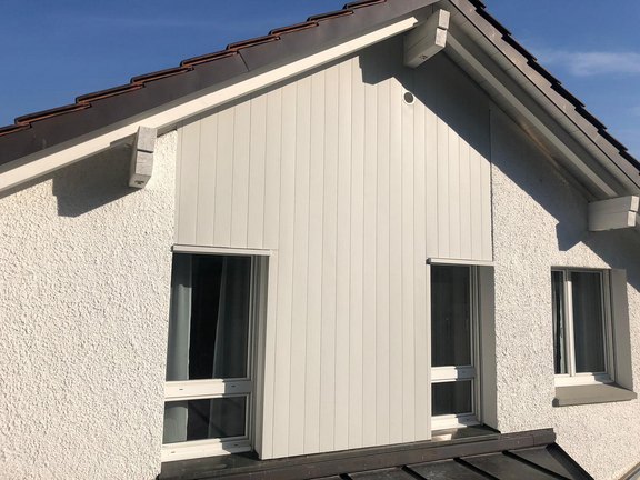 Fassadenverkleidung aus Aluminium an einem Giebel